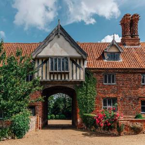 HalesLavish Tudor Estate & Gardens - Sleeps 25的一座古老的砖房,前面有拱门