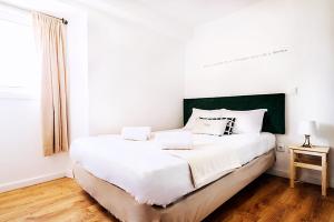 法蒂玛What Else Guest House - Fatima的一间卧室配有一张白色大床和绿色床头板