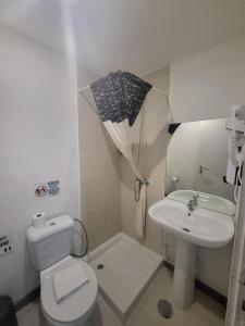 法蒂玛What Else Guest House - Fatima的浴室配有卫生间、水槽和雨伞。