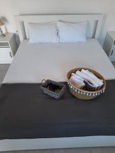 斯卡拉索提罗斯Villa Giotis Suite的一张带一碗毛巾和一篮毛巾的床