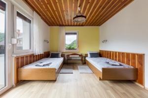 班斯卡比斯特里察Apartmaji Rupnik的带2扇窗户的客房内的2张床