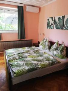 桑托德Oázis Apartman的卧室配有带枕头的床铺和窗户。