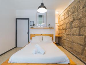 大加那利岛拉斯帕尔马斯Cathedral Apartment的卧室配有白色大床和砖墙