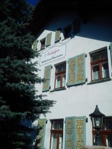 索斯诺夫卡Pensjonat Nostalgia的白色的建筑,有窗户,上面有标志
