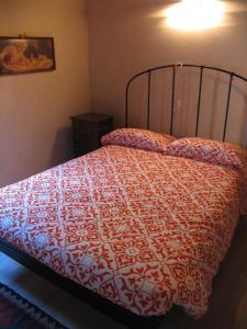 巴切诺Casa Vacanze La Meridiana的一间卧室配有一张带红色和白色棉被的床