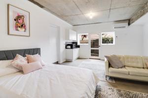 吉朗Highton Accommodation (Geelong)的白色卧室配有床和沙发