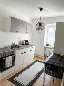 格蒙登Apartment in Gmunden的厨房配有白色橱柜和桌子