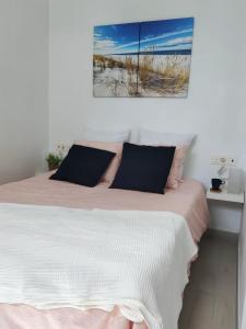 宏达海滩Paradise room near the beach的一间卧室配有一张带粉色和白色毯子的床