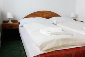 日利纳斯洛伐克酒店 的一张带白色床单的床和两张毛巾
