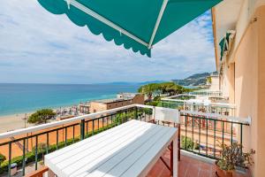 瓦里格提Le Casasse "Paradiso"的阳台设有白色长椅,享有海滩美景。