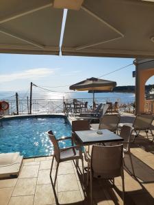 蒂锡利维科劳立海滩酒店的一个带桌椅的游泳池以及遮阳伞