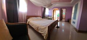 阿鲁沙Villa Jane的紫色墙壁客房里一间卧室,配有一张床