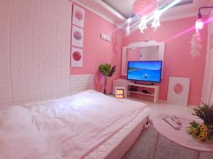 首尔Spring Light的粉红色的卧室配有床和电视