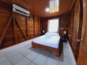 福尔图纳Cabaña Rural el Mirador的木制客房内的一间卧室,配有一张床