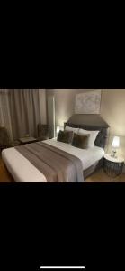 沙勒罗瓦机场公园酒店的一间卧室配有一张带两盏灯的大型白色床。