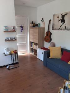 Villers-la-VilleÀ la pause bien méritée =)的客厅配有蓝色沙发和吉他