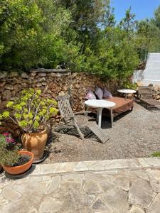 圣埃乌拉利亚retreat studio的一个带桌椅和石墙的庭院