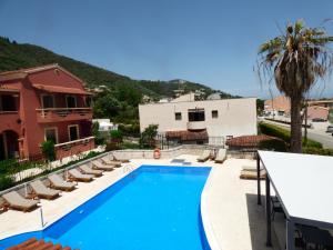 阿普索斯索菲亚别墅酒店的一座带躺椅的游泳池和一座建筑