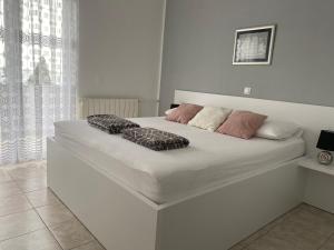 诺瓦利娅Emanuela 1的卧室内的一张带两个枕头的白色床