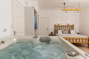 纳克索乔拉Aqua Naxos Apartments & Suites的配有床的房间,浴缸里装满了水