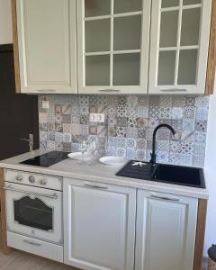 大特尔诺沃Joanna’s home的厨房配有白色橱柜和水槽