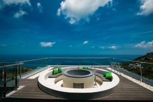 茶云莱海滩Villa Seawadee - luxurious, award-winning design Villa with amazing panoramic seaview的甲板上的热水浴池,背景为大海