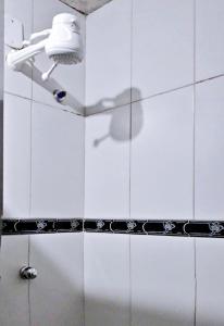 里约热内卢Solar Hostel Beach Copacabana的浴室铺有白色瓷砖,设有淋浴。