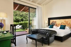 蒙泰亚尔真塔廖Argentario Lagoon Resort & Spa的一间卧室配有一张大床和一张沙发