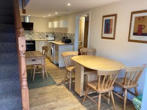 Long StrattonThe Shed的厨房以及带木桌和椅子的用餐室。