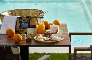 古瓦伊Volta Suites and Villas的桌上的一小盘食物,包括橘子和果汁