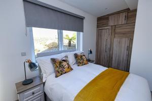 基拉尼Aghadoe Lodge的卧室配有带枕头的白色床和窗户。