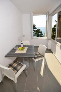 布雷拉Villa Dalmatia Apartments的一间带桌子和两把椅子的用餐室