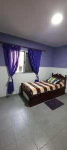 圣达菲Tomay Apart的一间卧室配有一张紫色墙壁和窗户的床