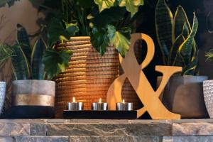 德班维尔Modern Shabby Chic Apartment的一张桌子,上面有两根蜡烛和一个金色的大标志