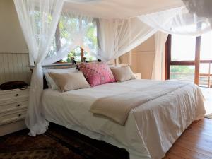 Santa MariaCasa Karibu at Santa Maria Machangulo Mozambique的卧室配有白色的床、窗帘和窗户