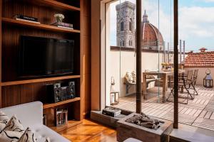 佛罗伦萨Repubblica Firenze Luxury Apartments | UNA Esperienze的一间带电视和大窗户的客厅