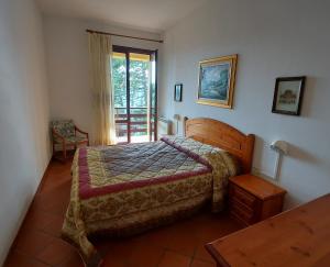 塞尼奥河畔帕拉佐洛Antico Borgo I Cancelli的一间卧室设有一张床,并有通往阳台的门