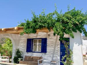 迈洛波塔斯Spiti Apartment的白色的房子,有蓝色的窗户和树