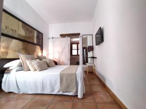 马贝拉Casa Silca的卧室配有白色的床和电视。