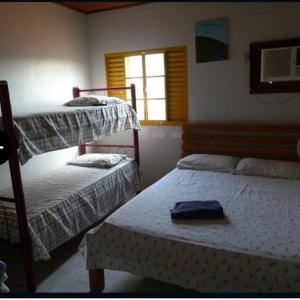 ItaberabaPousada Casarrara的一间卧室设有两张双层床和一扇窗户。
