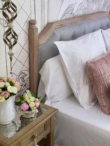 奥利奥Hotel Boutique Txanka Erreka PARKING INCLUIDO的一张带白色枕头和花朵的桌子