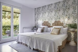奥利奥Hotel Boutique Txanka Erreka PARKING INCLUIDO的一间卧室配有一张带花卉壁纸的床