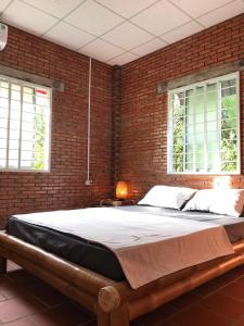 槟知Nguyet Que Homestay & Tours的卧室设有一张砖墙内的大床