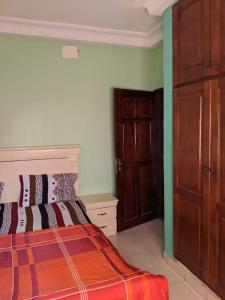 雅温得Appart meublés Yaounde的一间卧室配有一张床和一扇木门