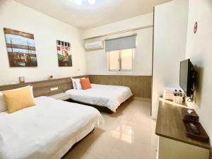 金宁乡八八古藝悅禾民宿的酒店客房设有两张床和电视。