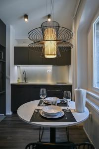 卢布尔雅那Strict city apartments的厨房里一张桌子,上面放着两杯眼镜和吊灯