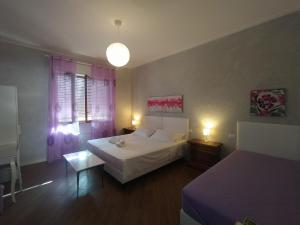 卡麦奥雷B&B Villa la Bouganville的一间卧室配有一张床、一张桌子和两张床