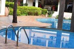 阿伯来Premium 2 BHK Green Suites的蓝色水中的酒店的游泳池