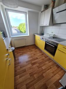 罗斯托克6 bedroom Private APARTMENT & Lounge的一间设有黄色橱柜和大窗户的厨房