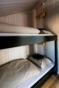 Sandgerði桑德格迪小屋酒店的带木墙的客房设有两张双层床。